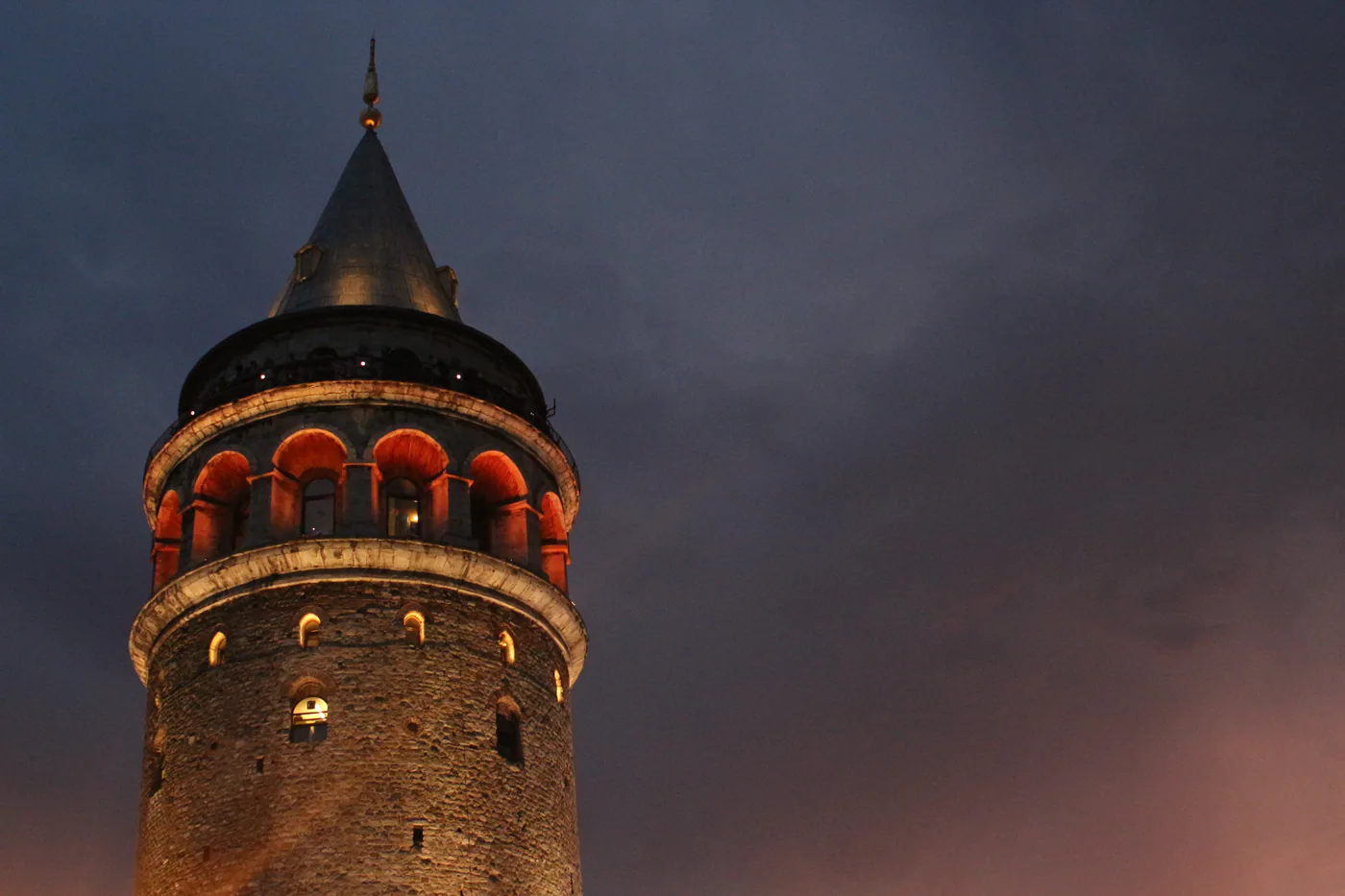 Galata Tower illuminated against the evening sky